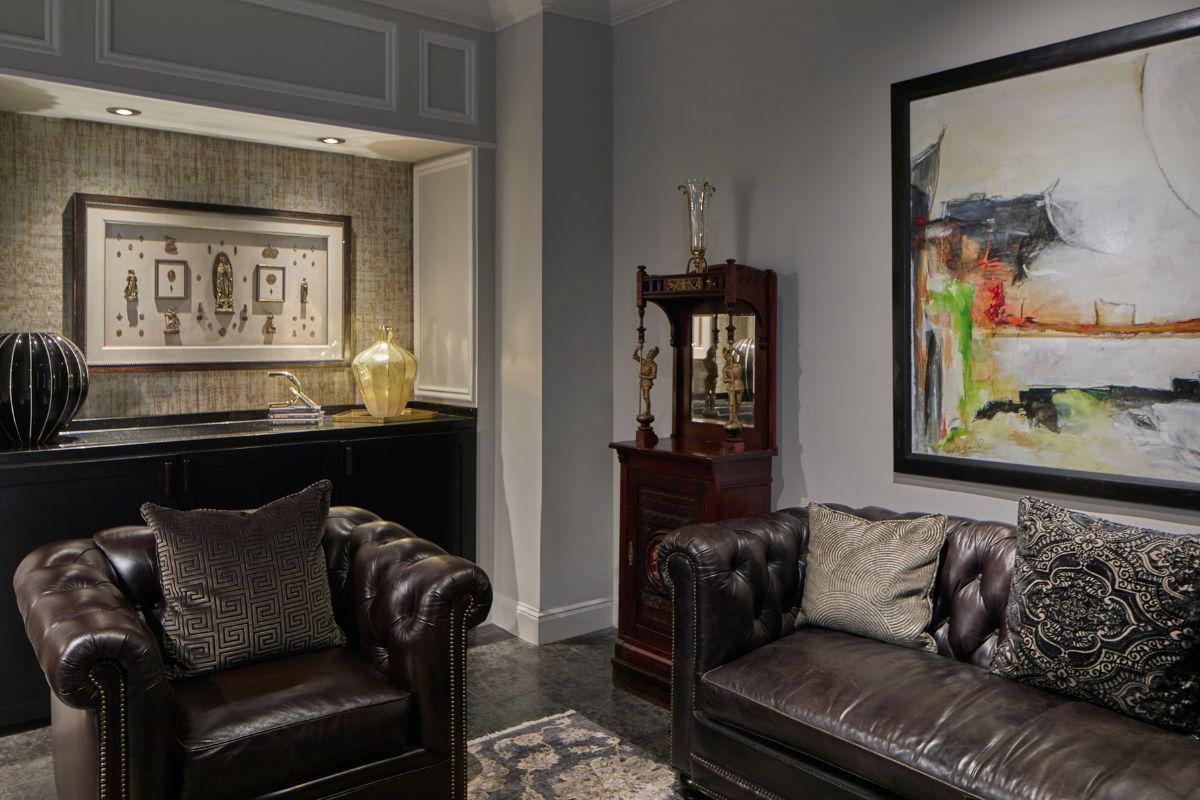 a room with leather couches and a painting