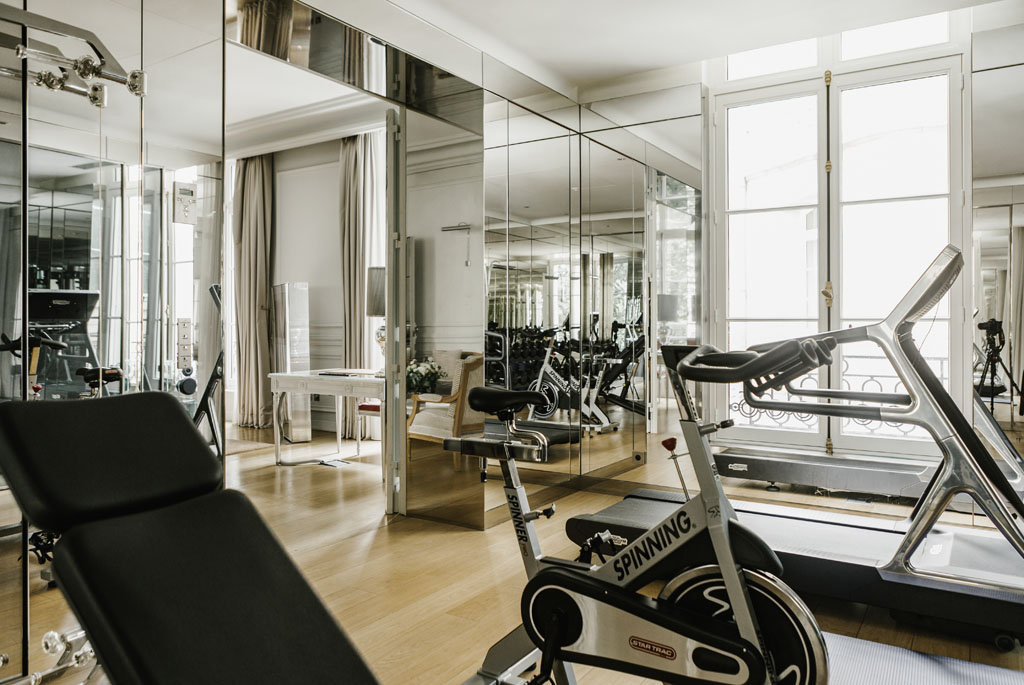 a room with exercise bikes and a mirror wall