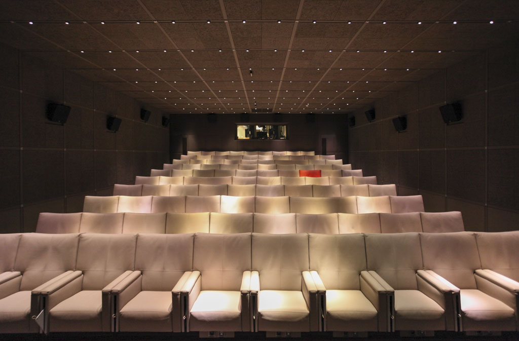 a row of white chairs in a theater