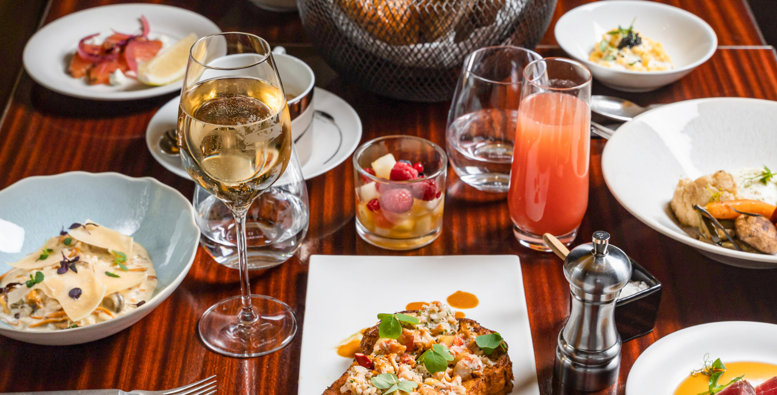 a plate of food and glasses of wine on a table