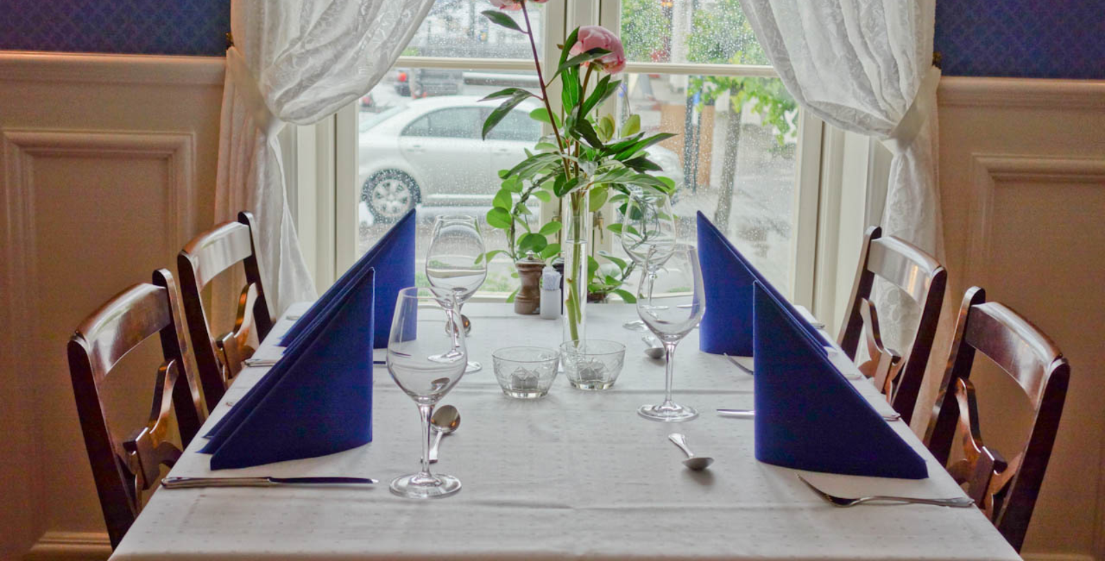 a table with glasses and a vase of flowers