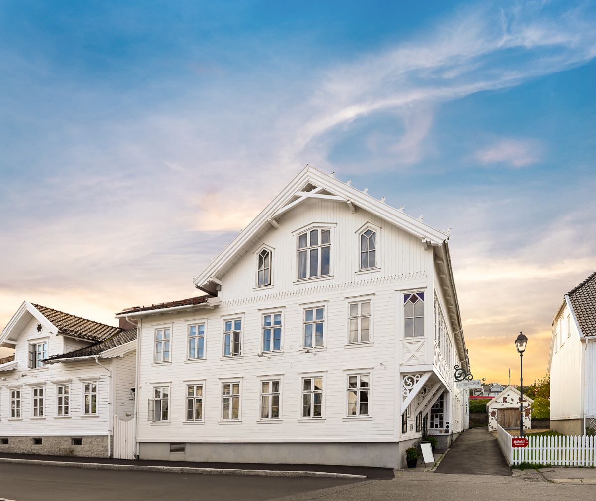 a white building with a fence and a street light
