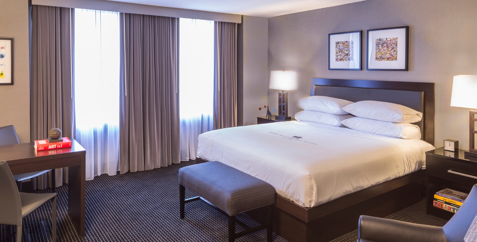 a bed with a lamp and a table in a hotel room