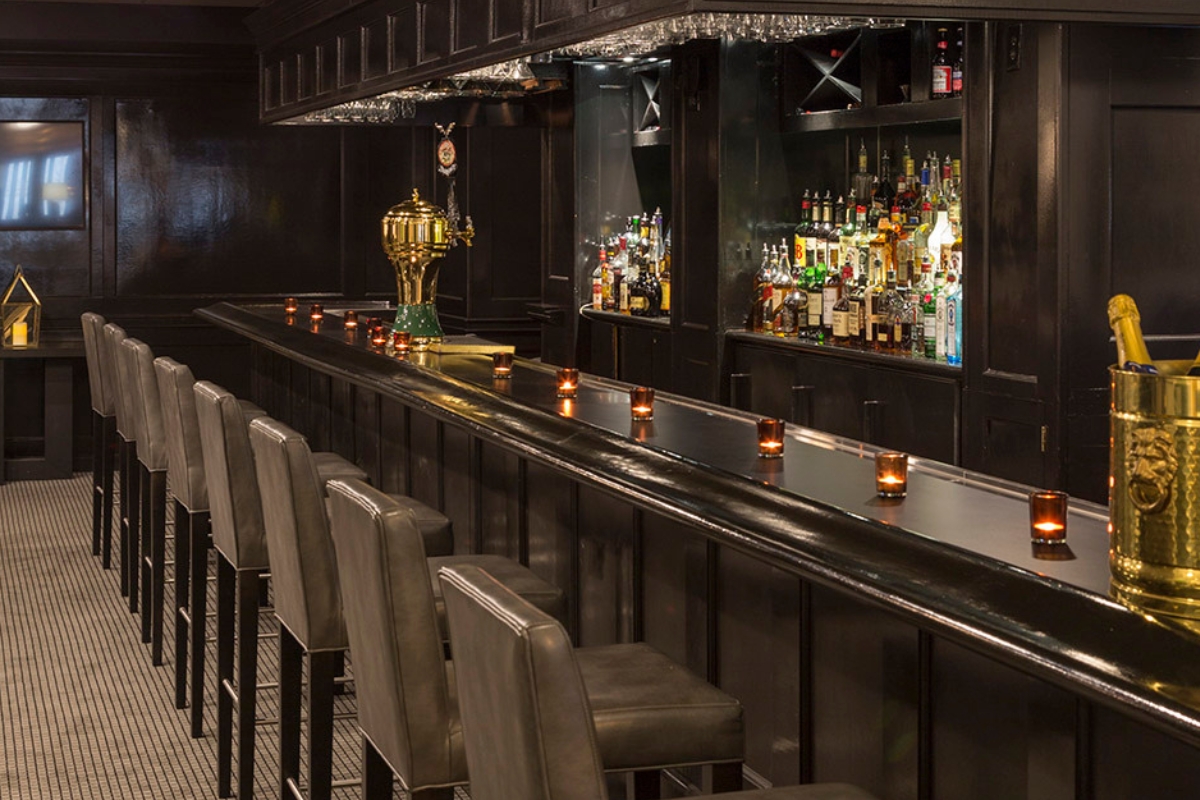 a bar with a gold trophy on top and a row of chairs