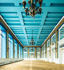 a large room with blue ceiling and chandeliers