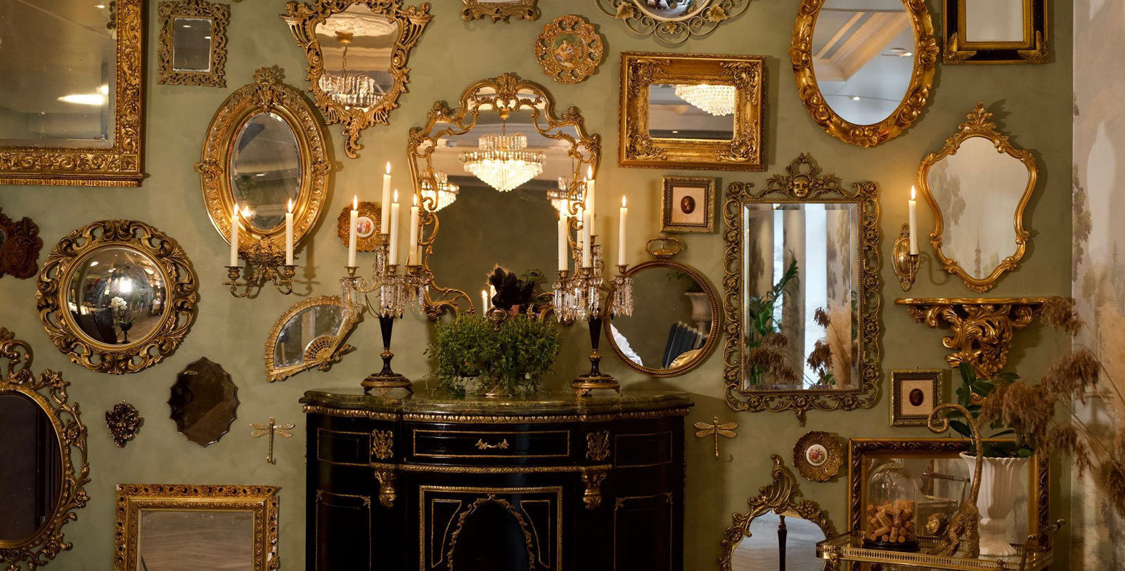 a wall with mirrors and a table with candles