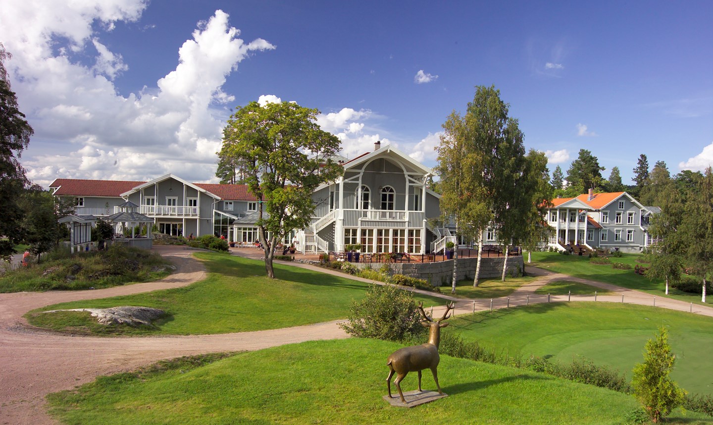 a large building with a statue of a deer in the middle of a golf course