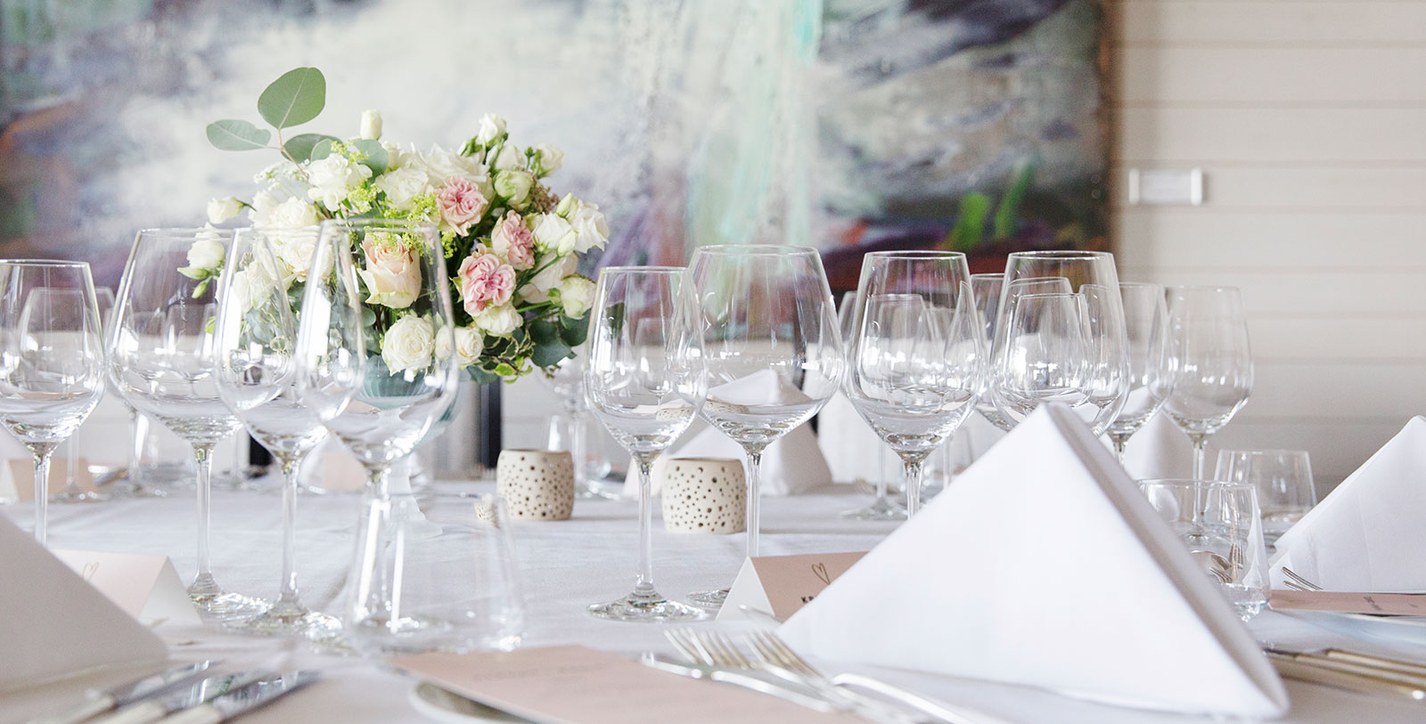 a table with wine glasses and flowers