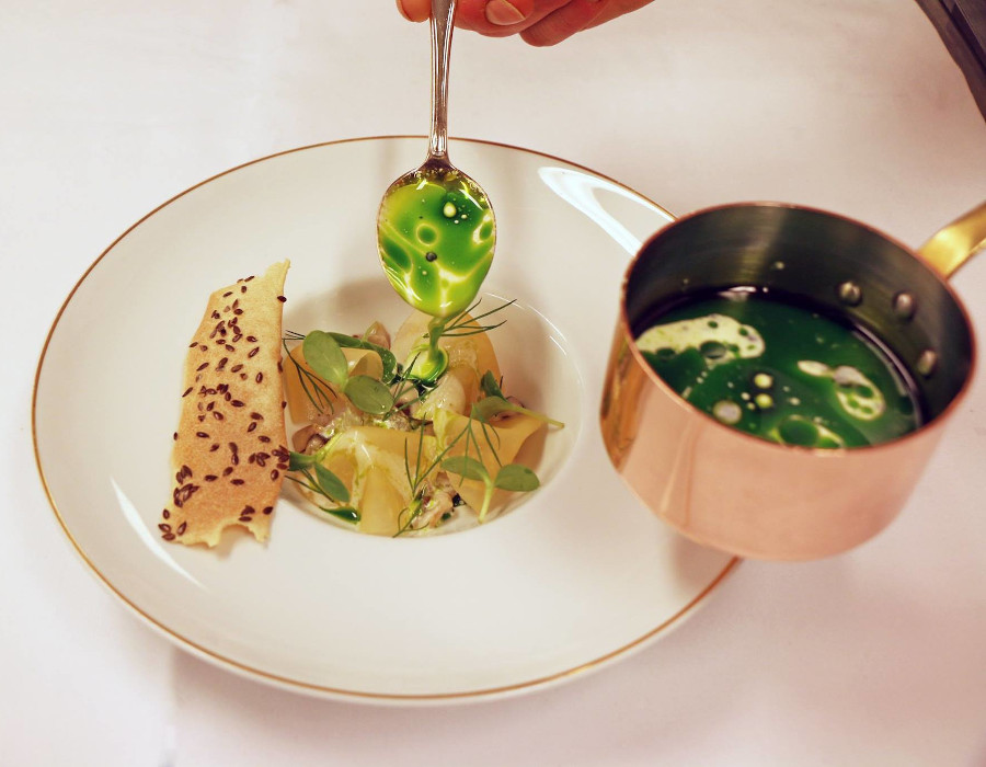 a spoonful of green soup on a plate