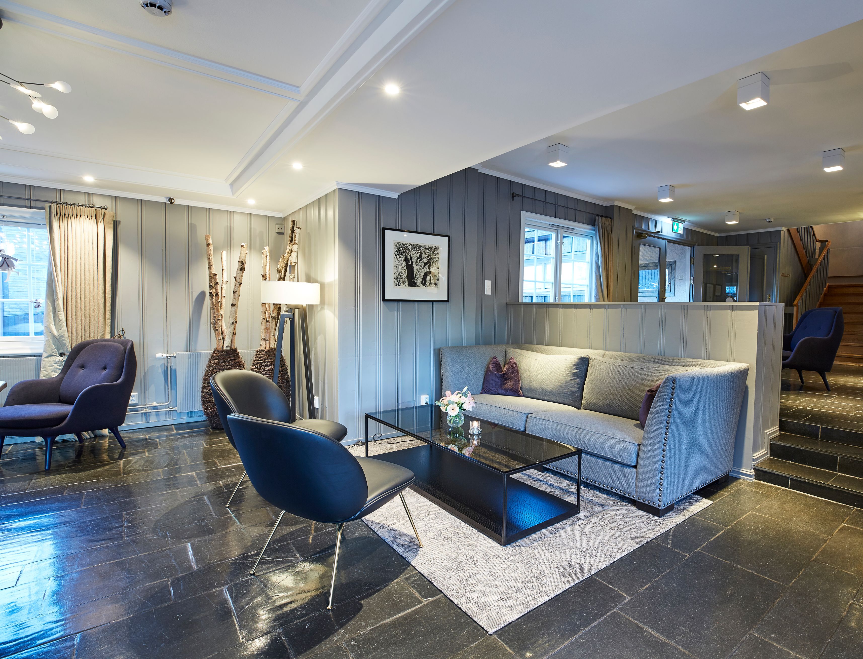 a room with a couch and chairs