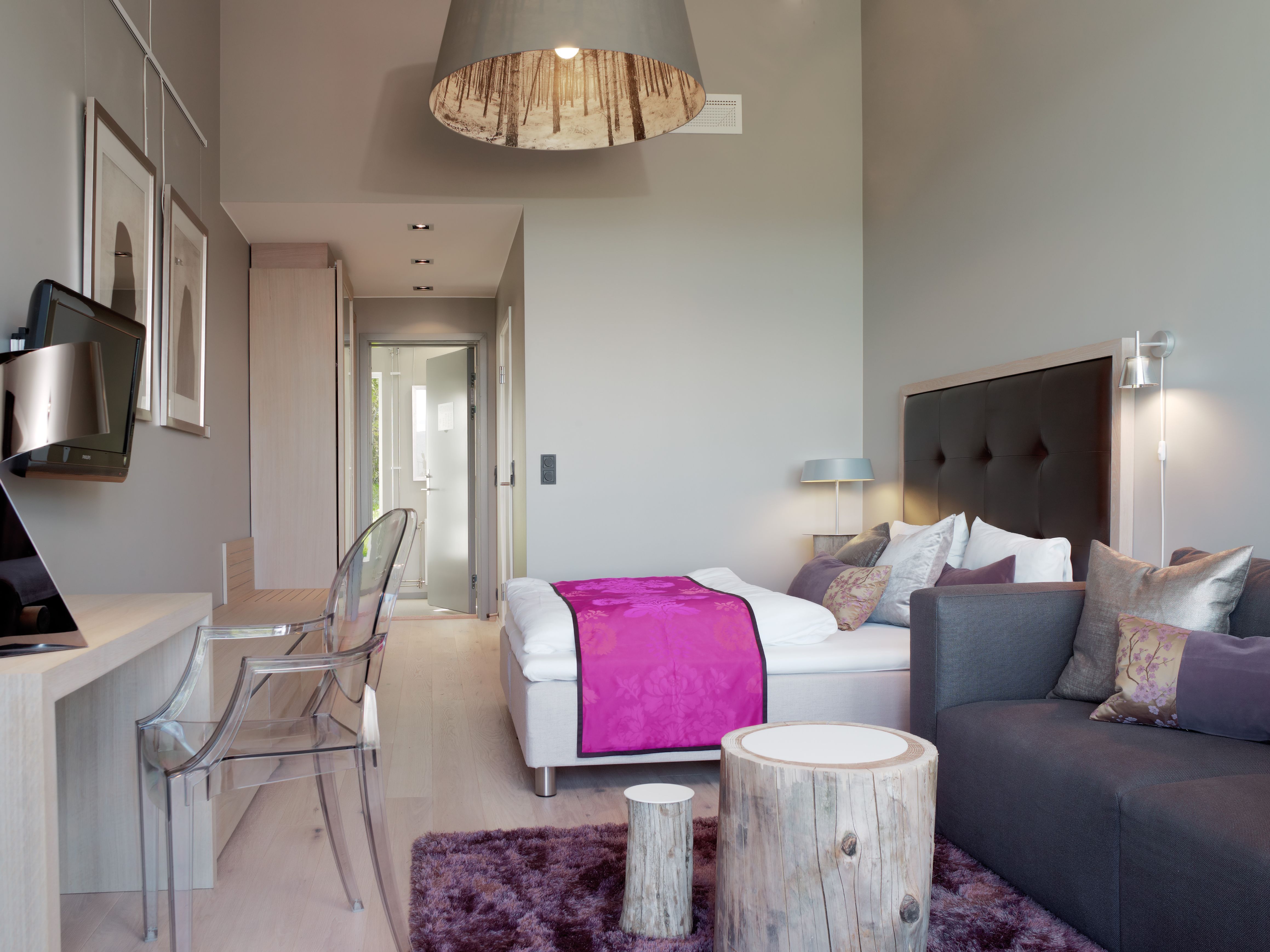 a bedroom with a pink blanket and a purple rug