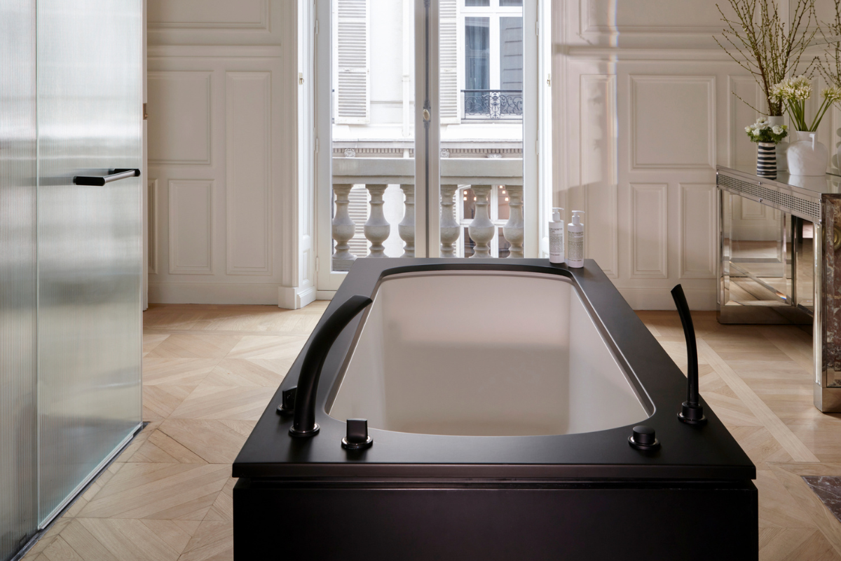 a bathtub in a room with a window and a balcony