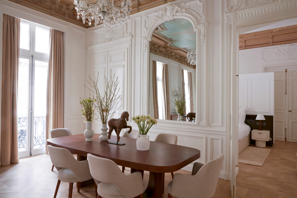 a dining room with a mirror and a table with flowers
