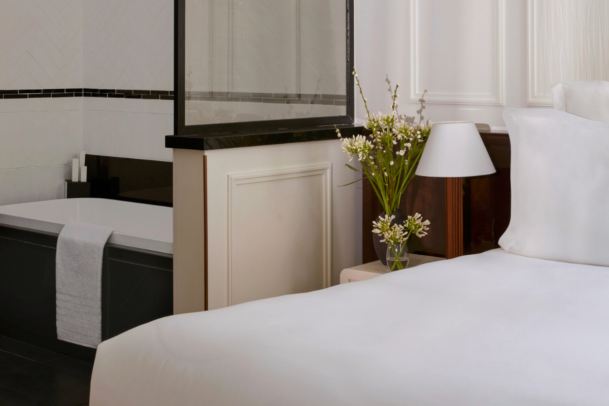 a white bed with flowers on a table
