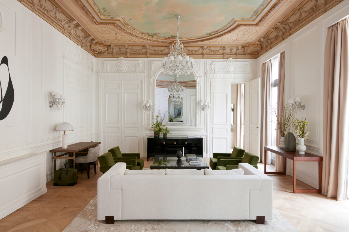 a room with a white couch and green chairs