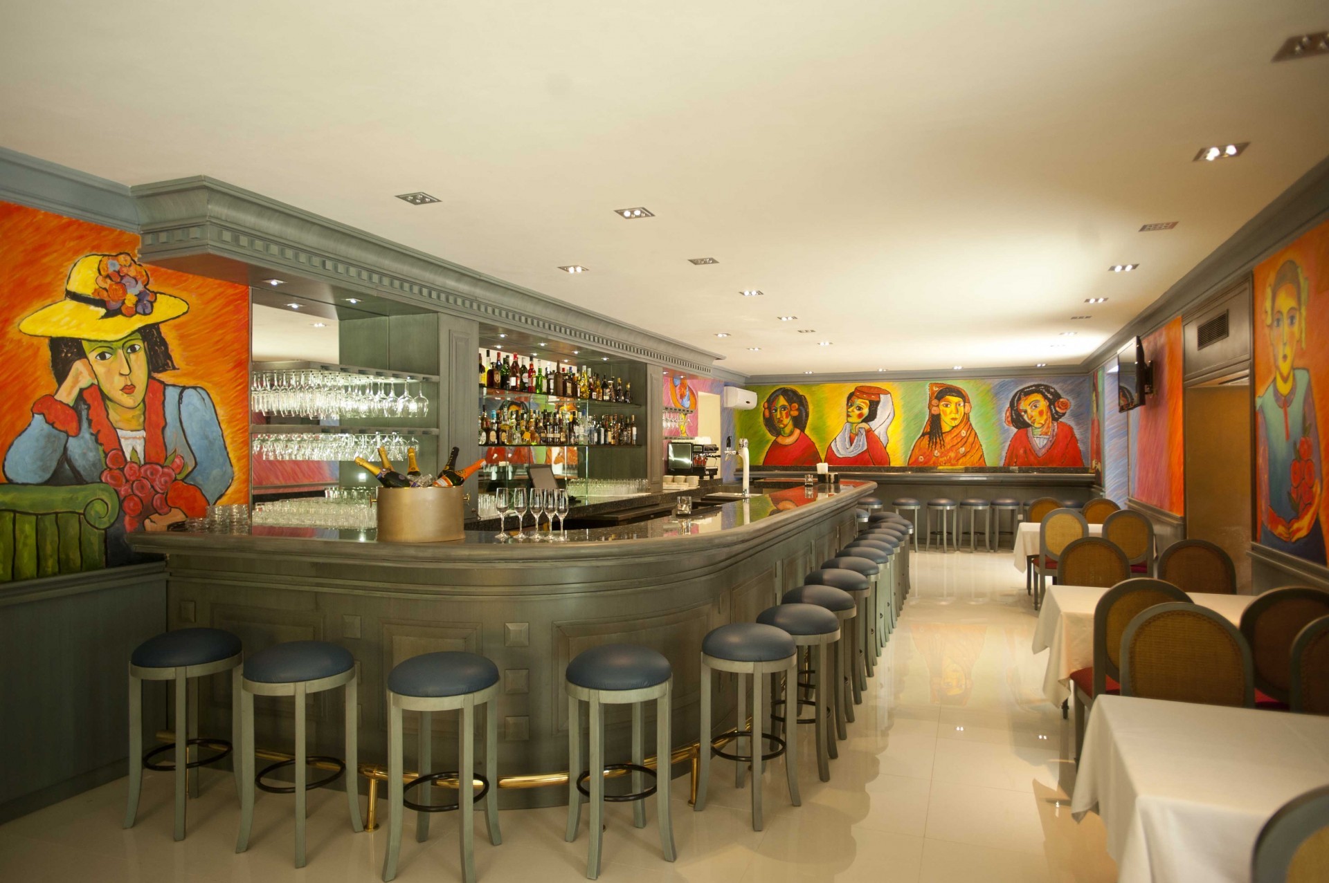 a bar with chairs and glasses
