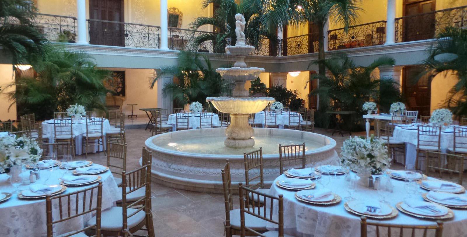 a fountain in a room with tables and chairs