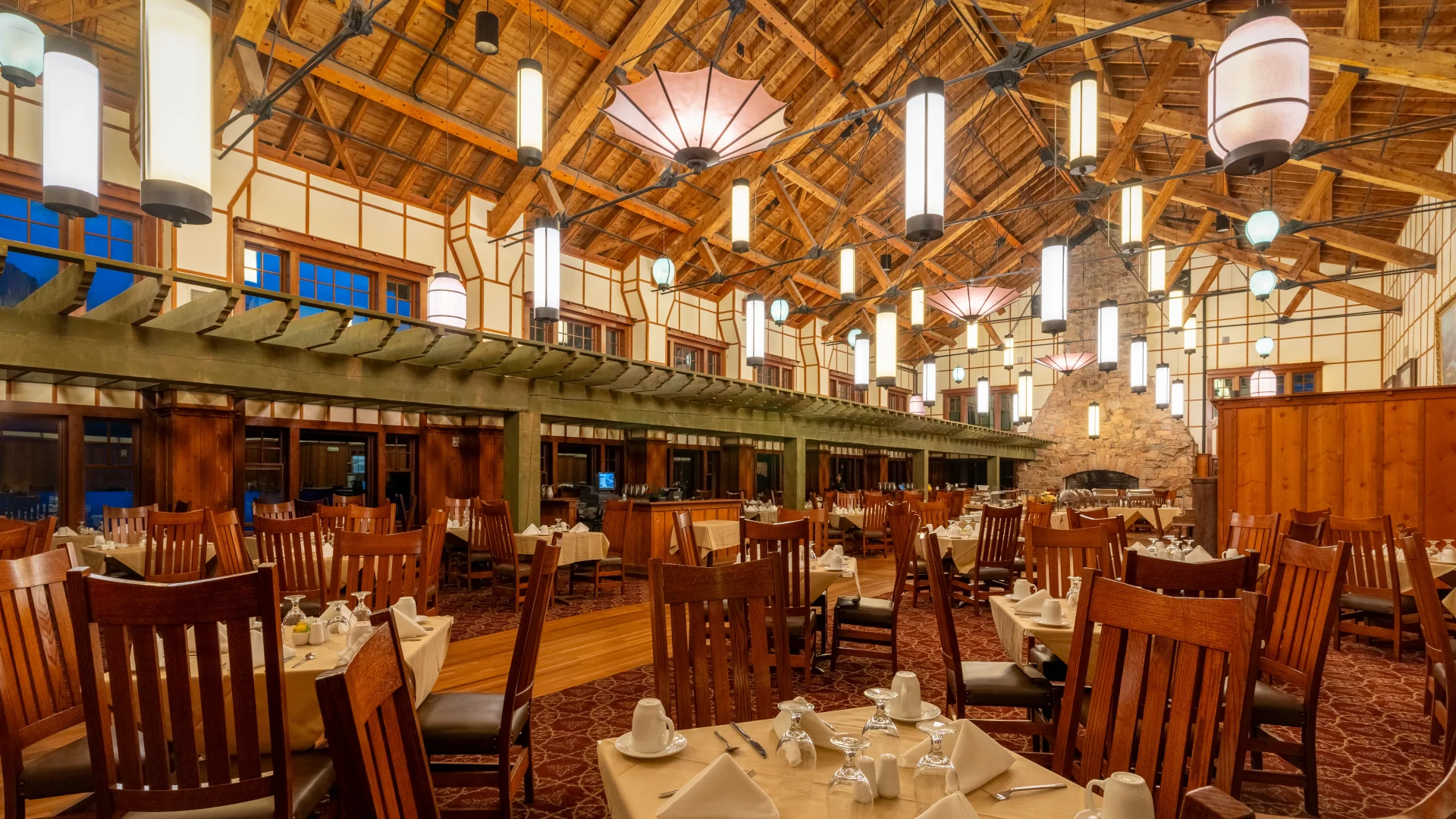 a room with tables and chairs and a ceiling with lights