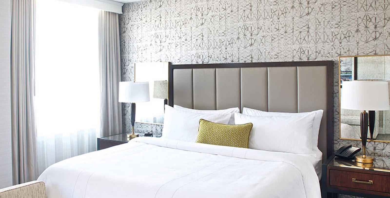 a bed with white sheets and a lamp in a room