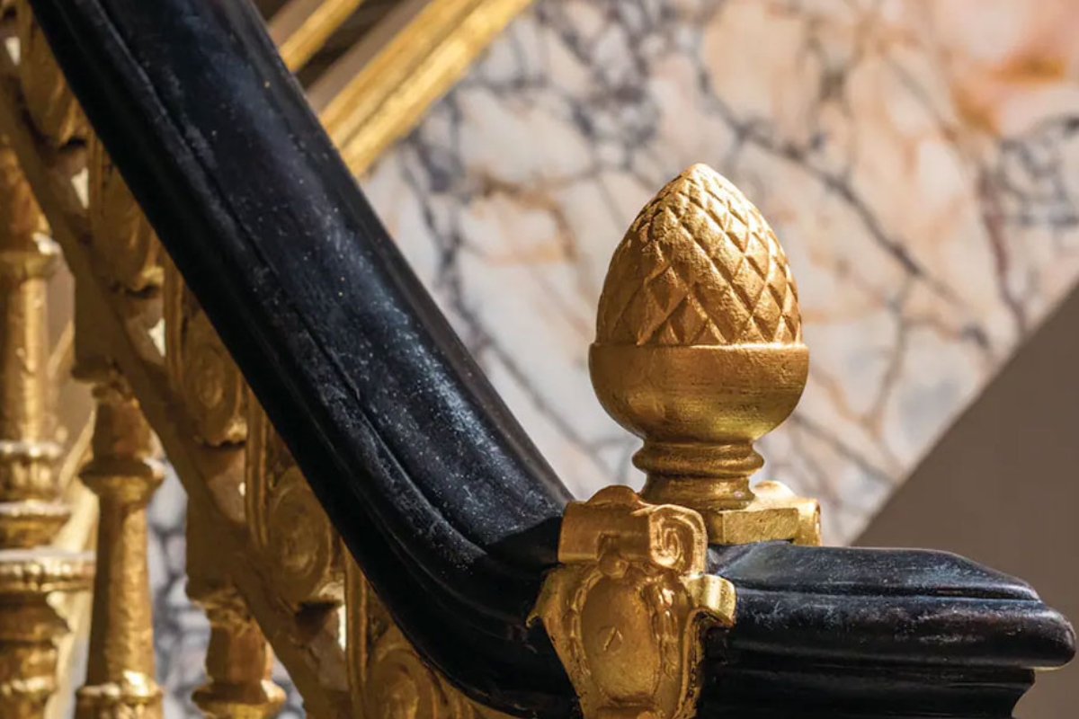 a gold pineapple on a black and gold staircase