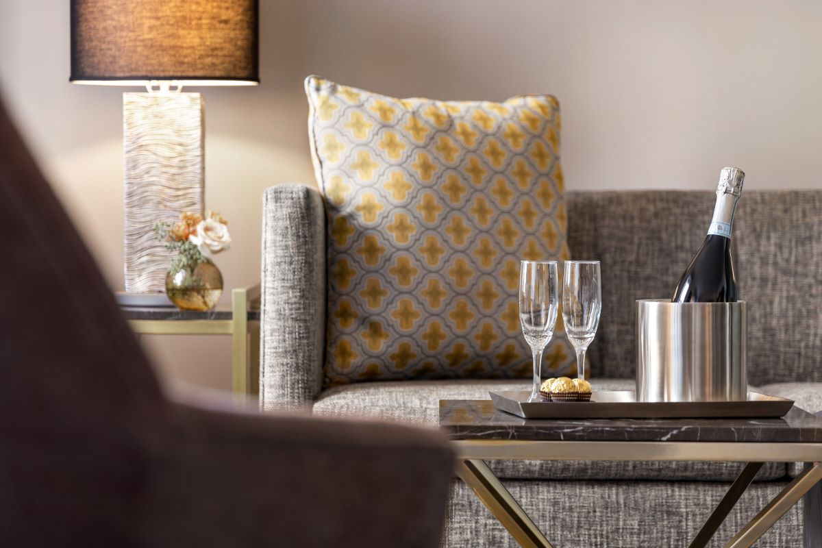 a table with wine glasses and a vase on it