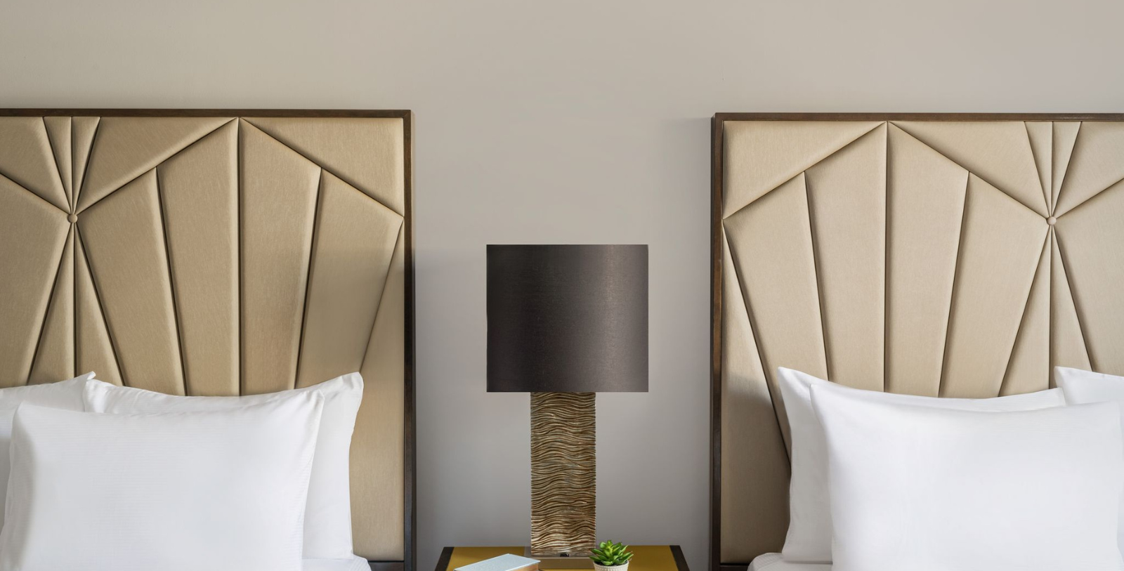 a lamp on a table next to a bed