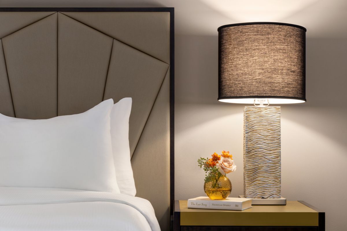 a lamp next to a bed