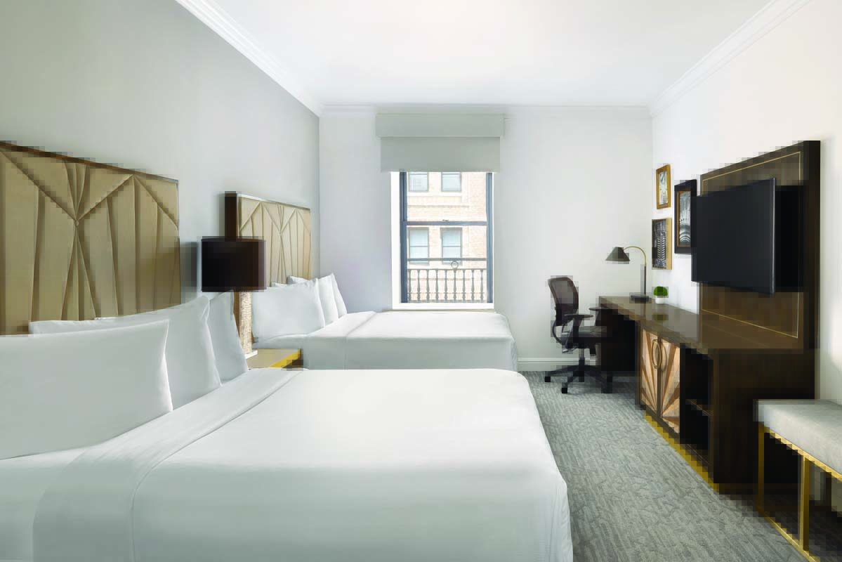 a room with two beds and a desk