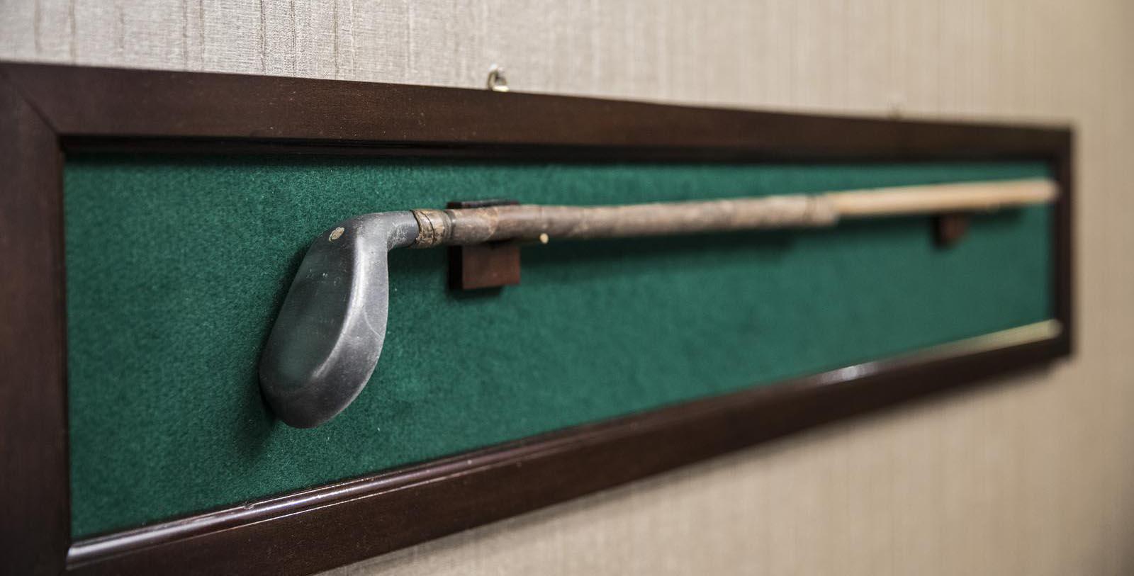 a golf club on a green felt board