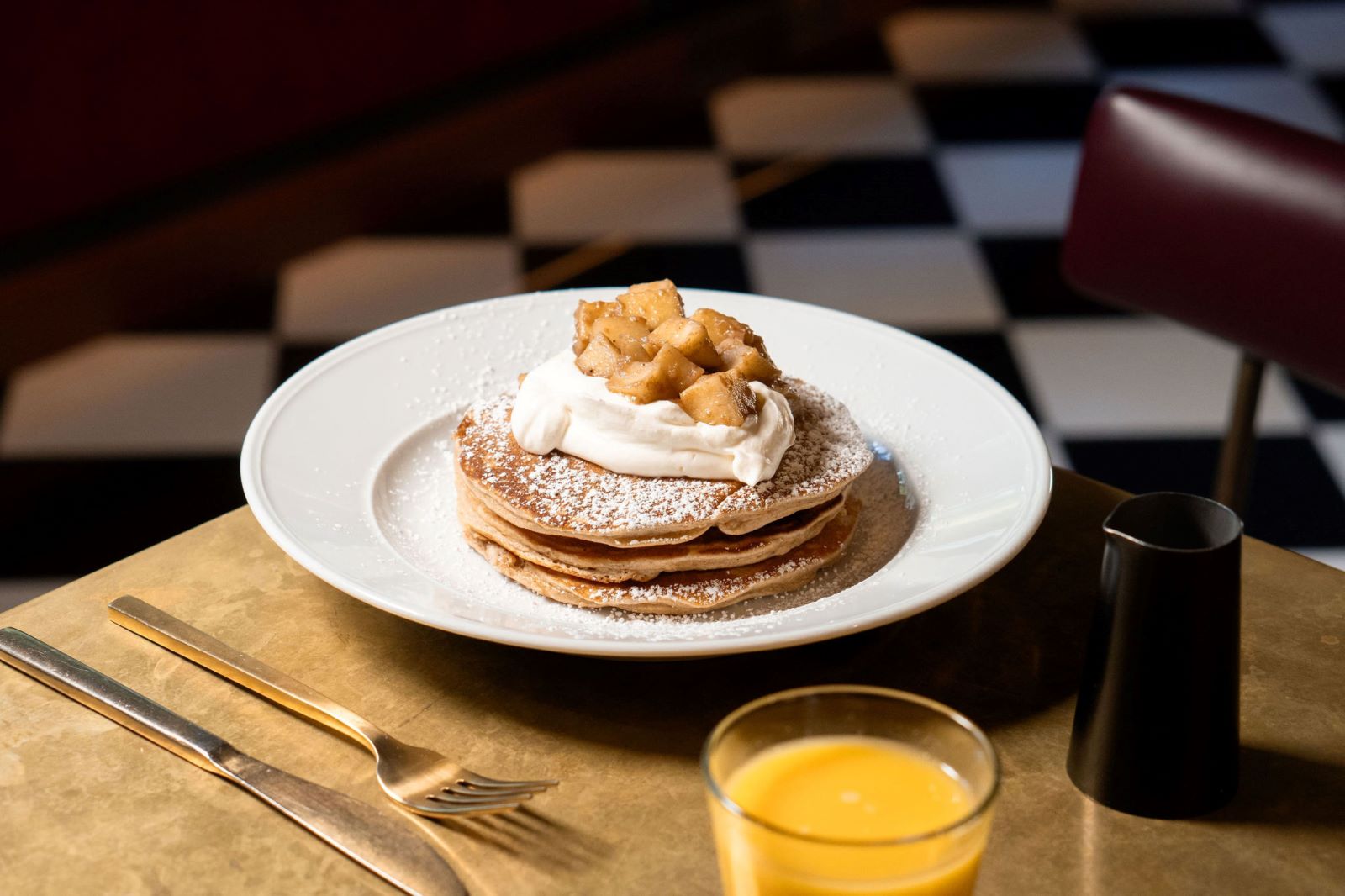 a plate of pancakes with whipped cream and fruit on top