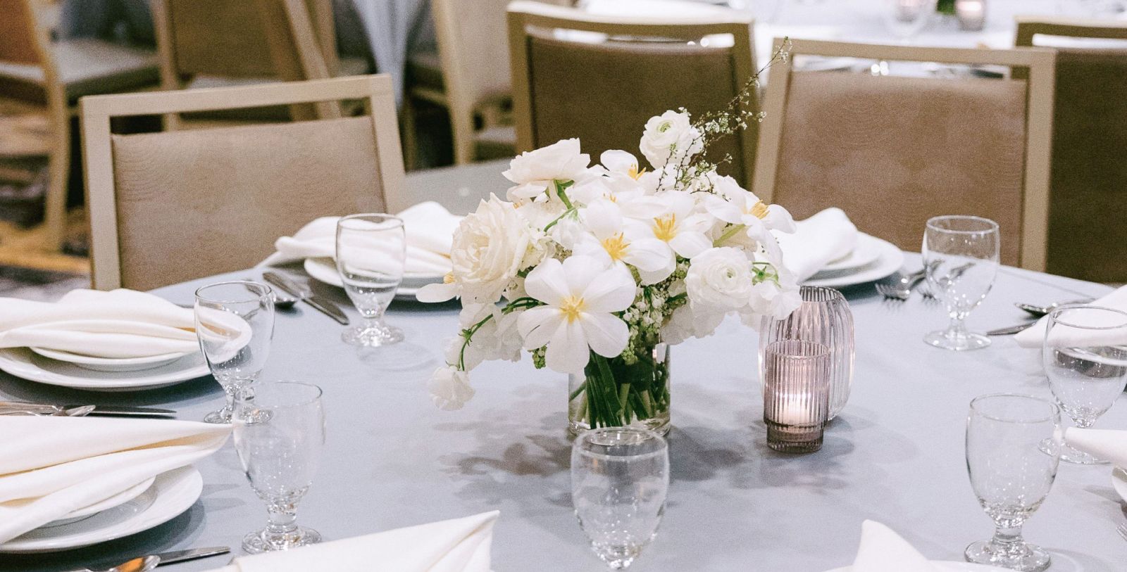 a table with white flowers and candles