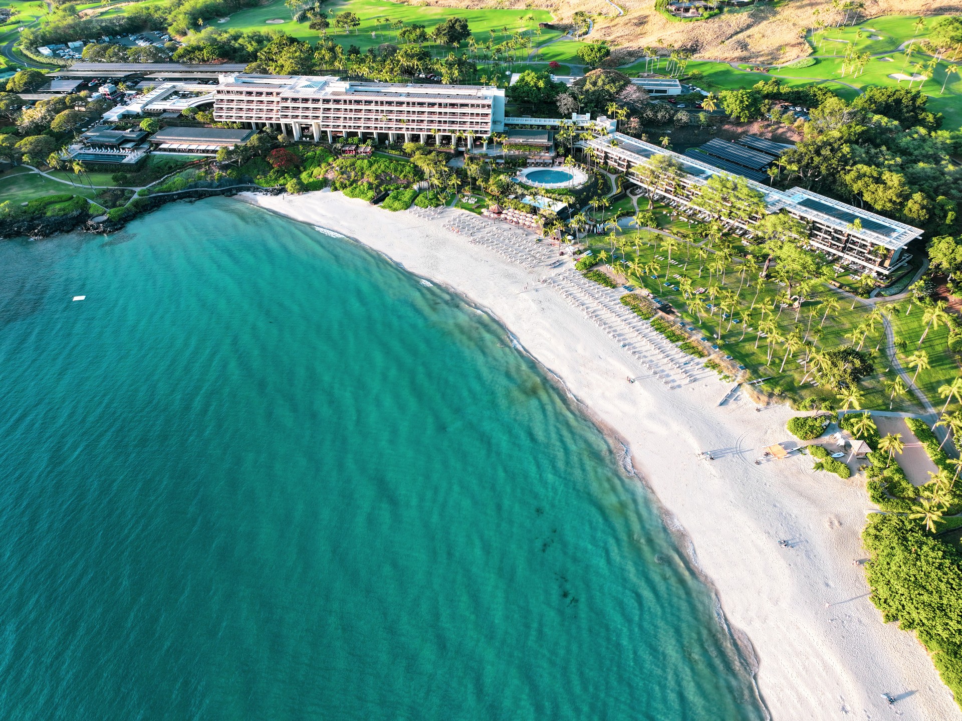 a beach with a building and a pool