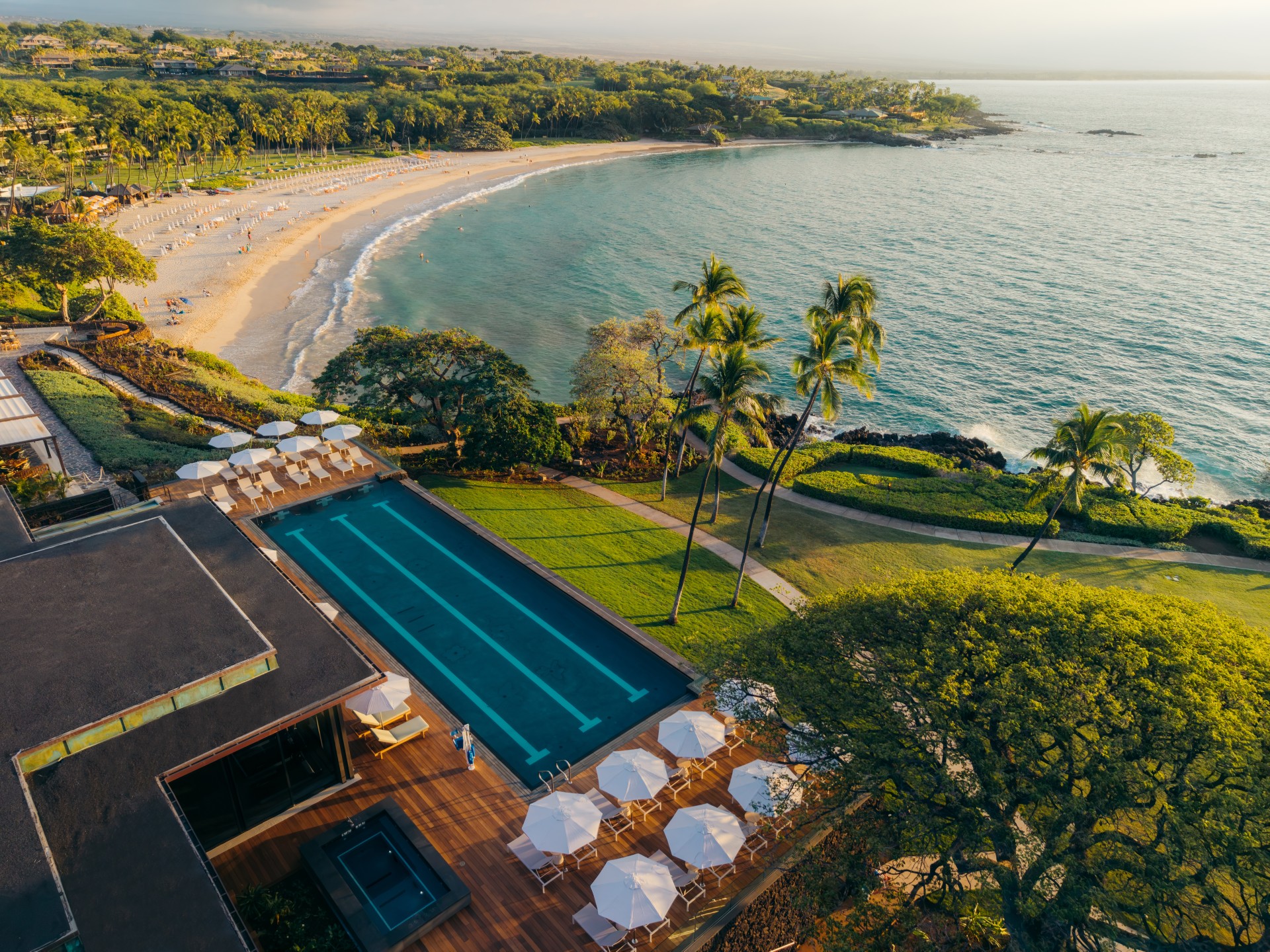 a swimming pool and beach with trees and sand