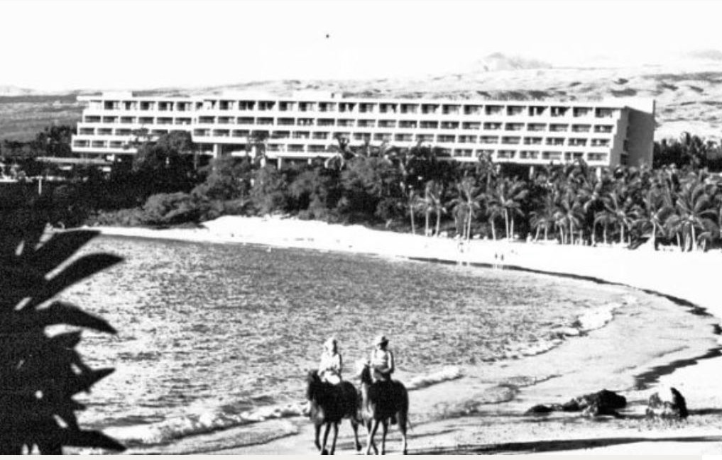 a couple of people riding horses on a beach
