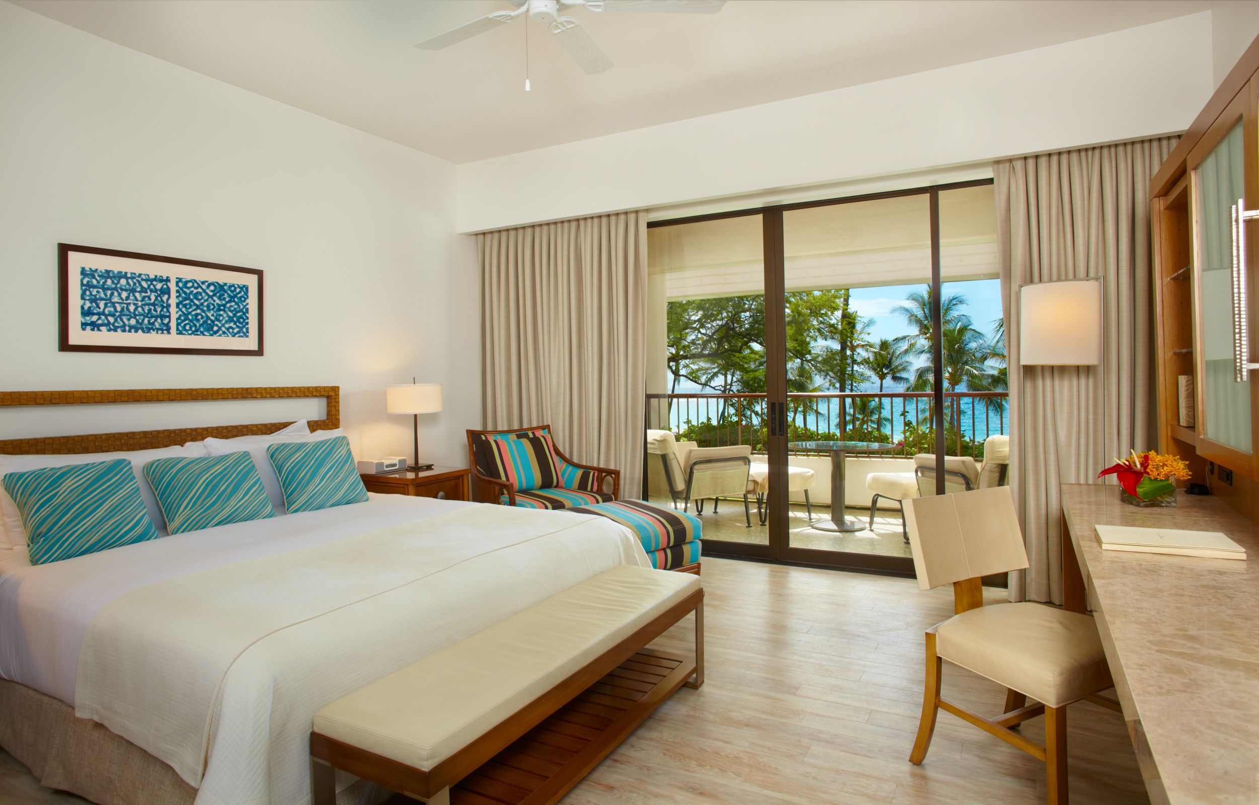 a room with a bed and chairs and a balcony