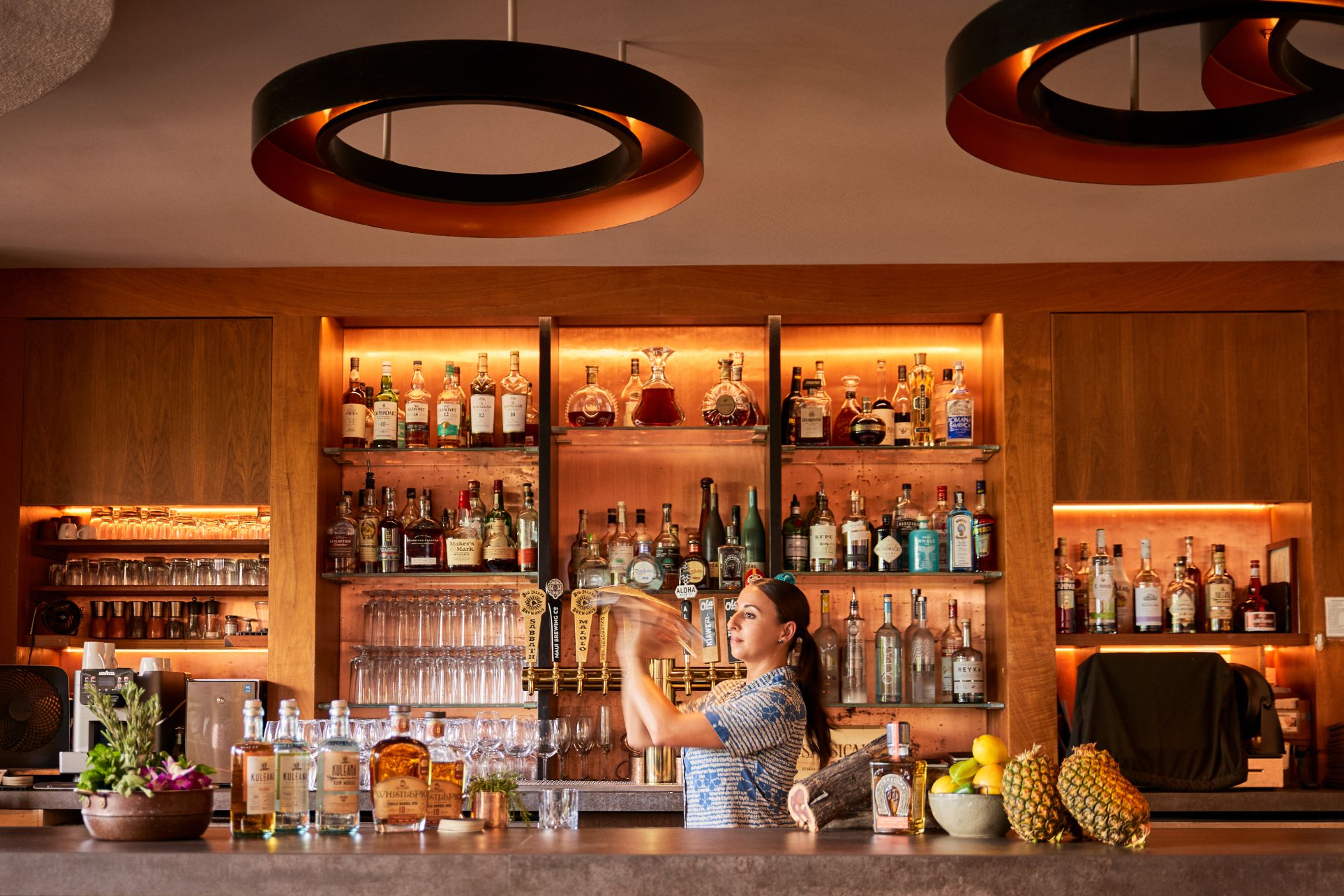 a woman making a drink at a bar
