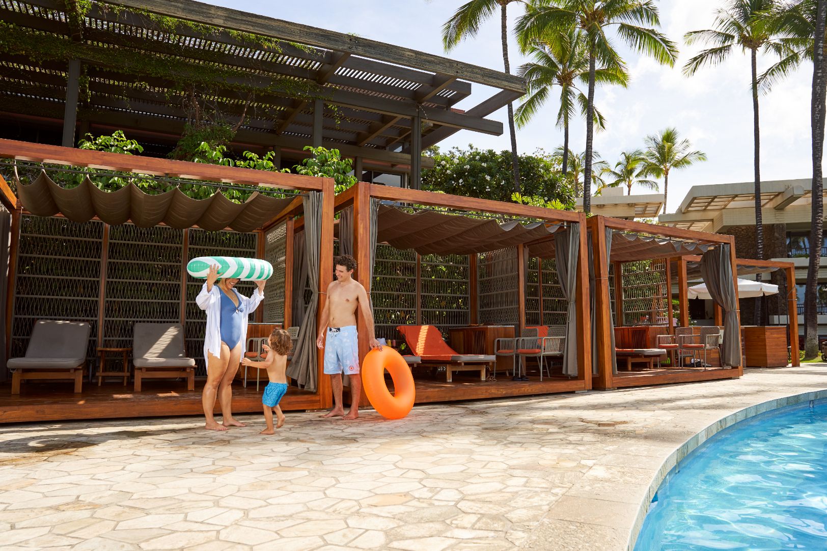 a group of people standing next to a pool