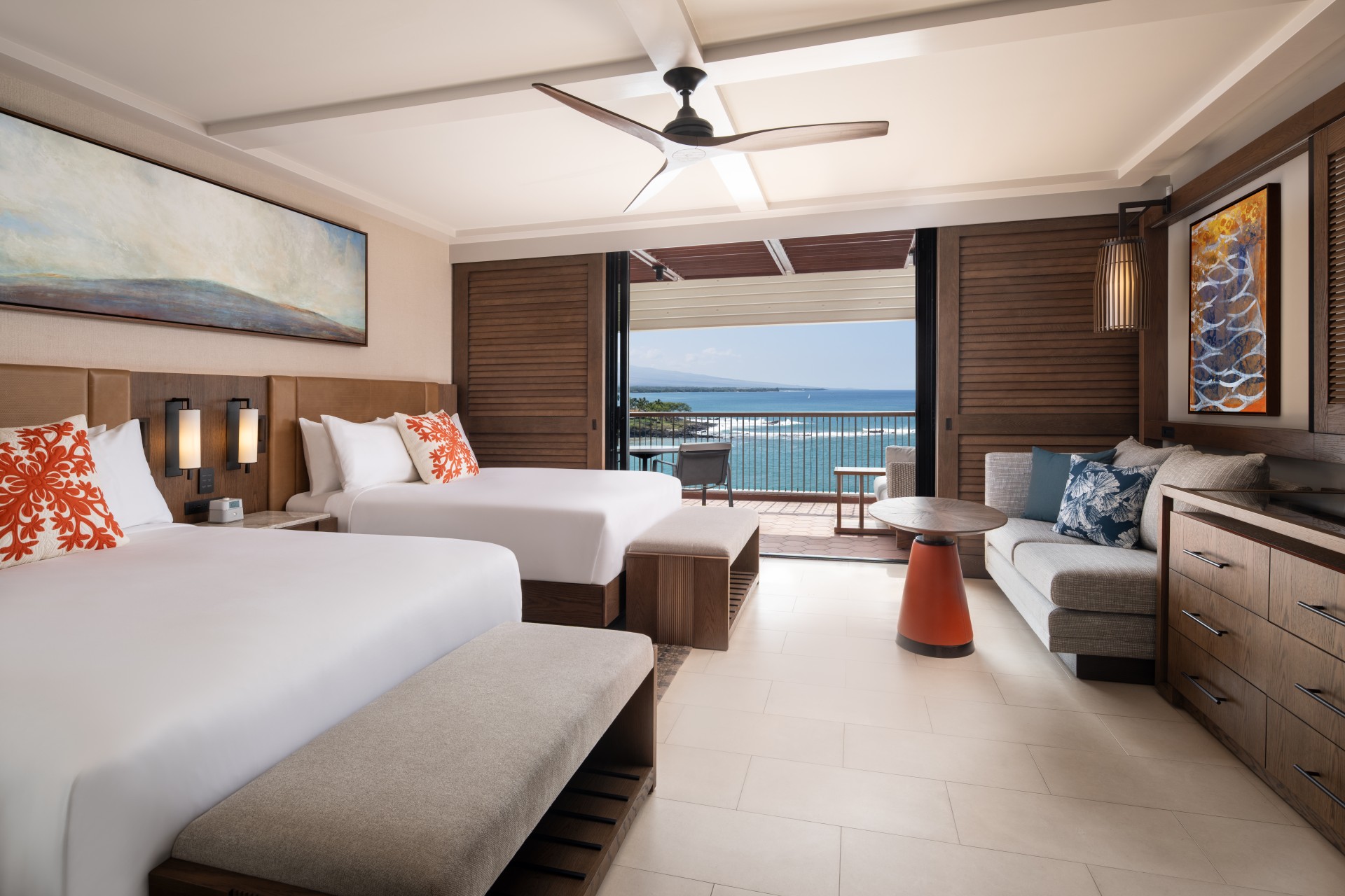 a room with two beds and a balcony overlooking the ocean