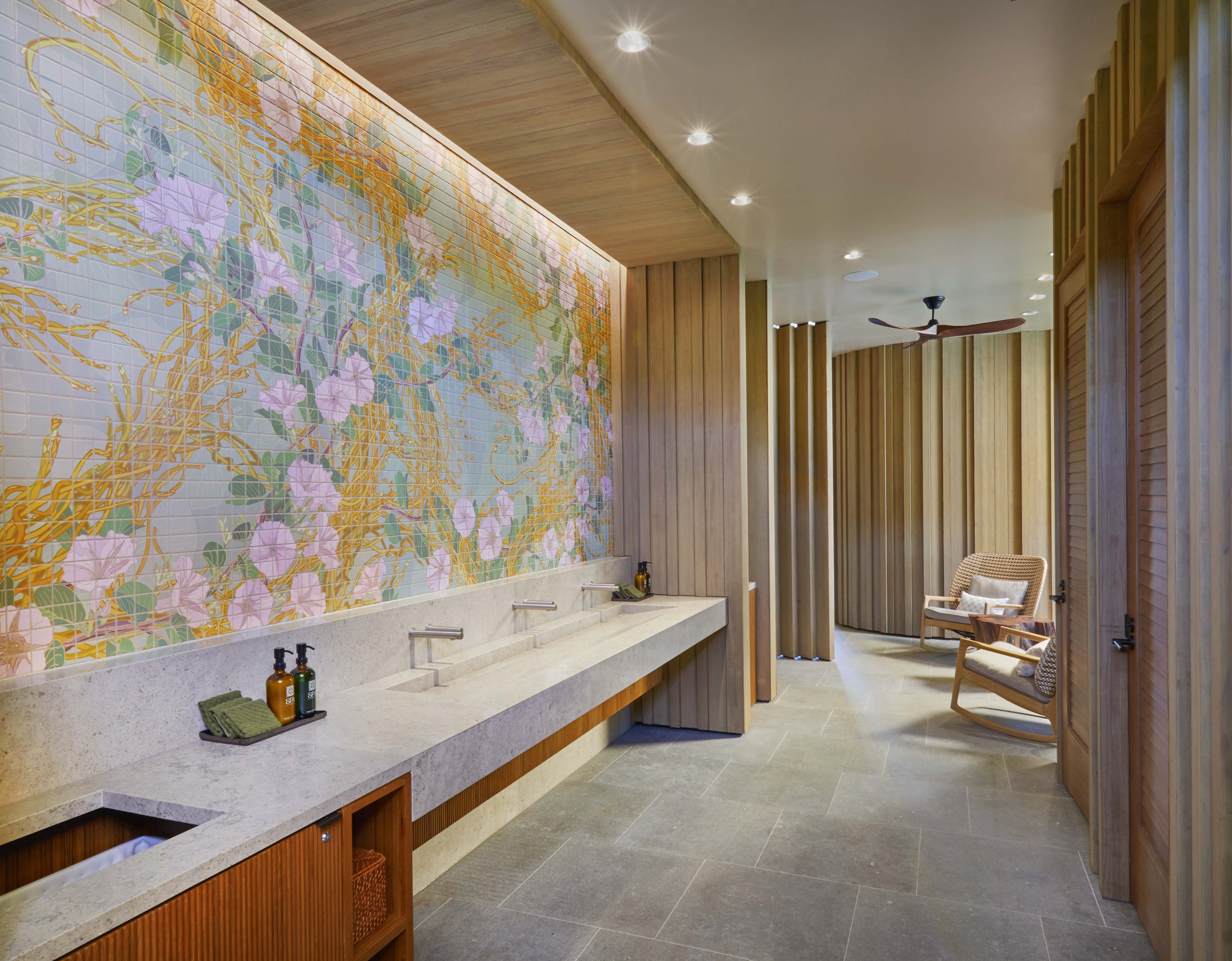 a bathroom with a tile wall and a sink