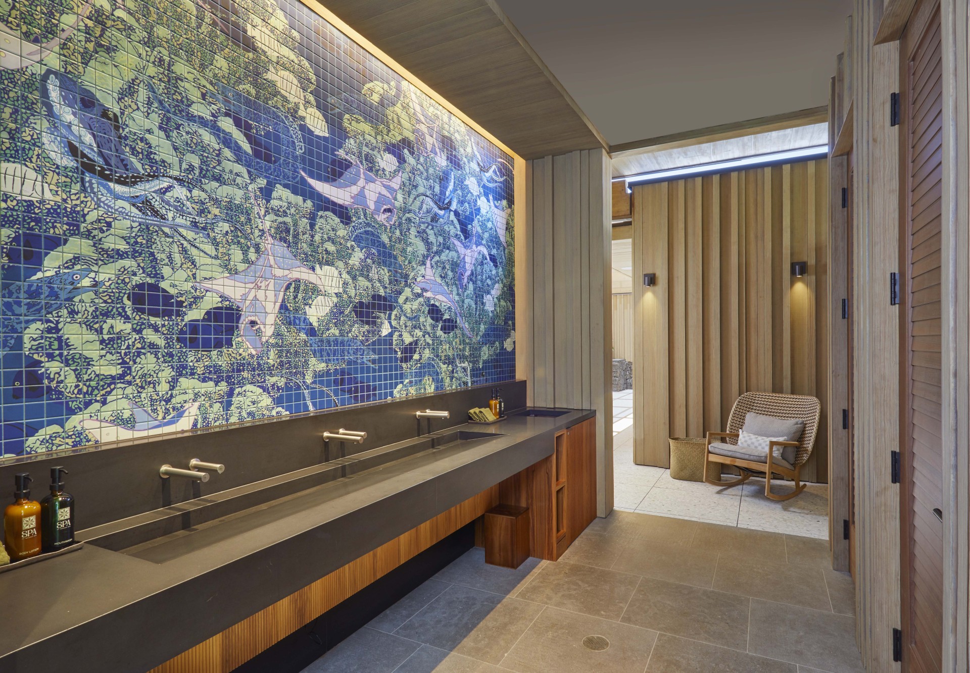 a bathroom with a tile wall and a large sink