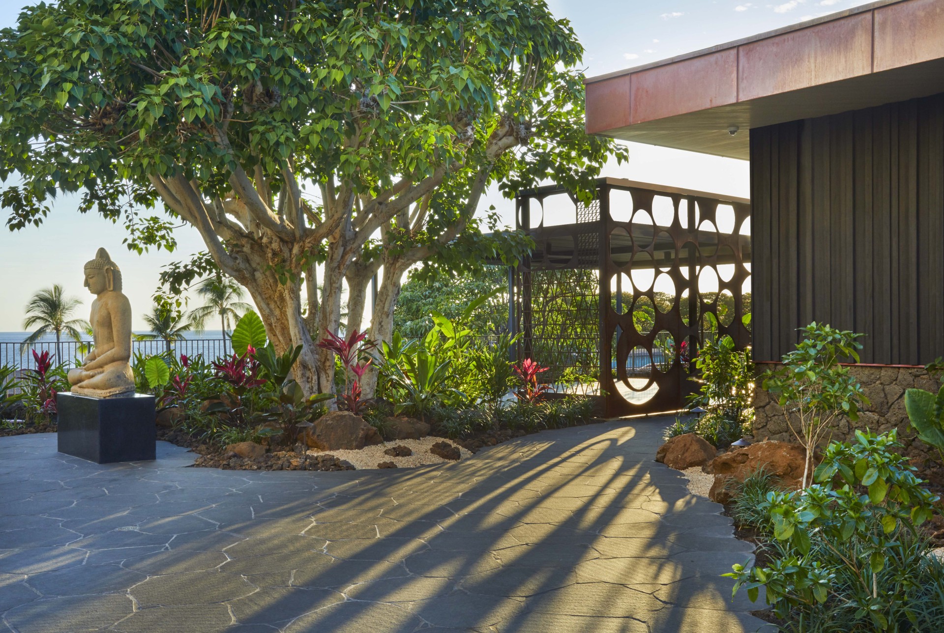 a walkway with a metal gate and trees