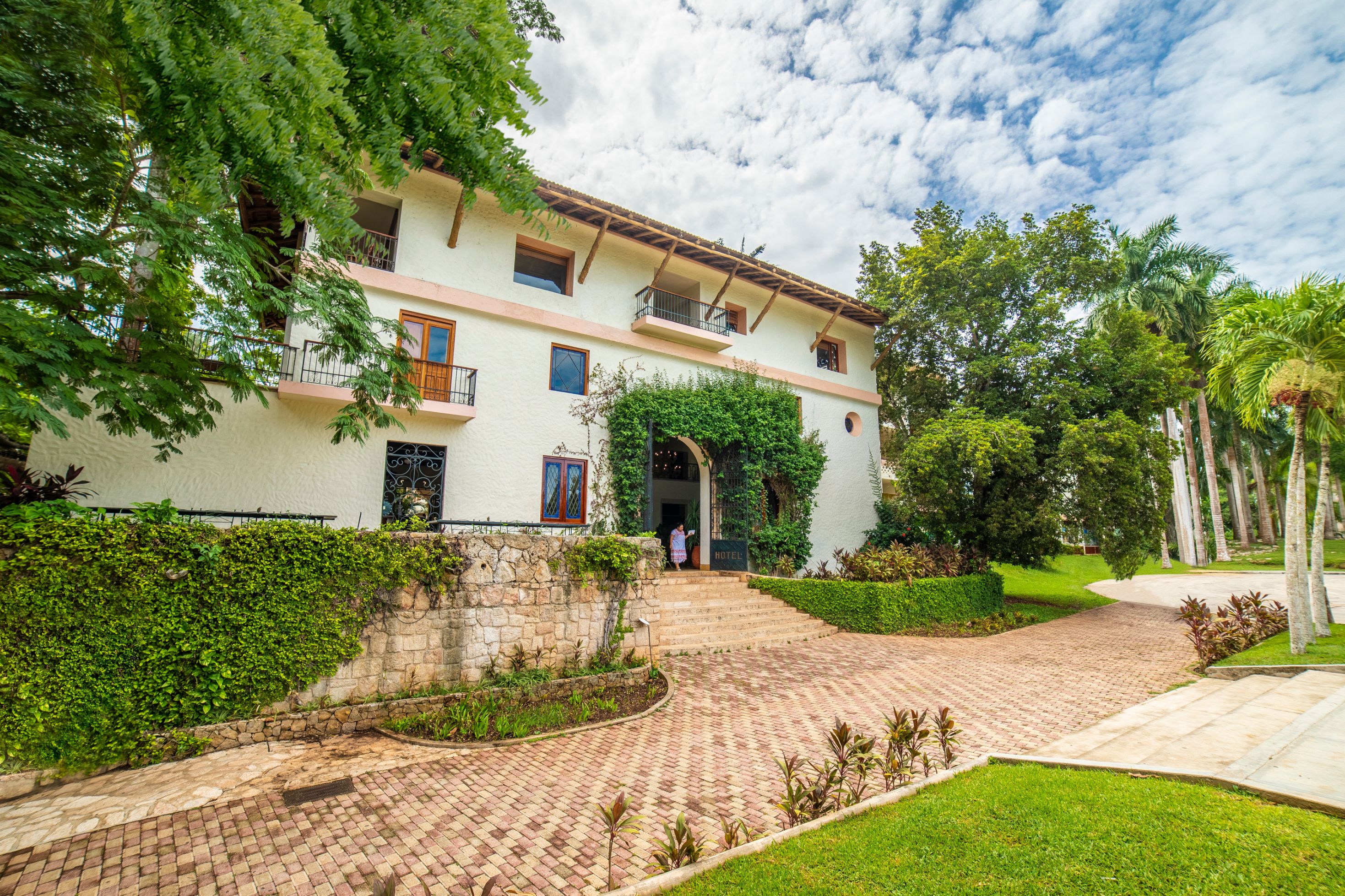 a building with a brick walkway and trees