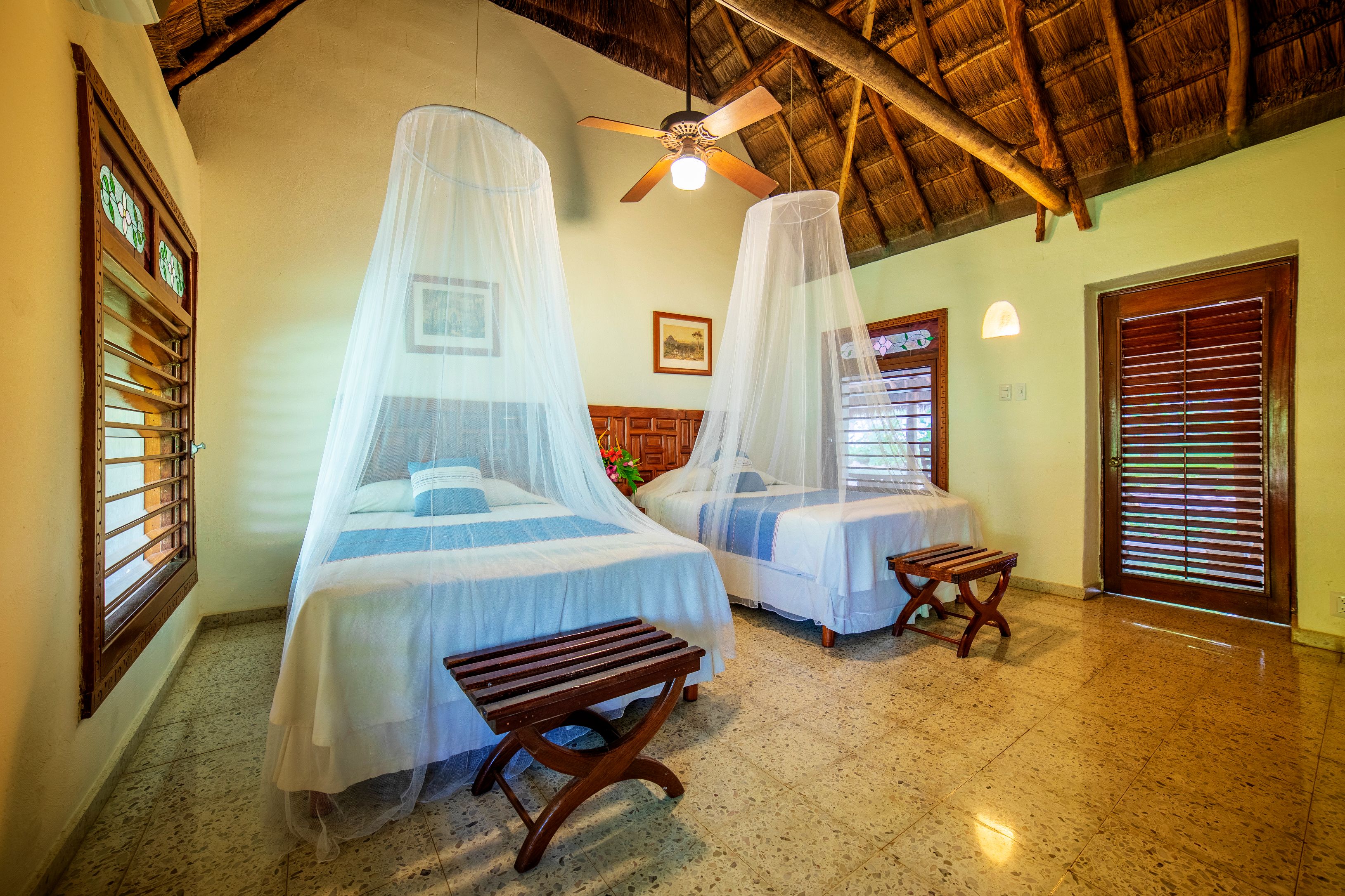 a room with two beds and a ceiling fan