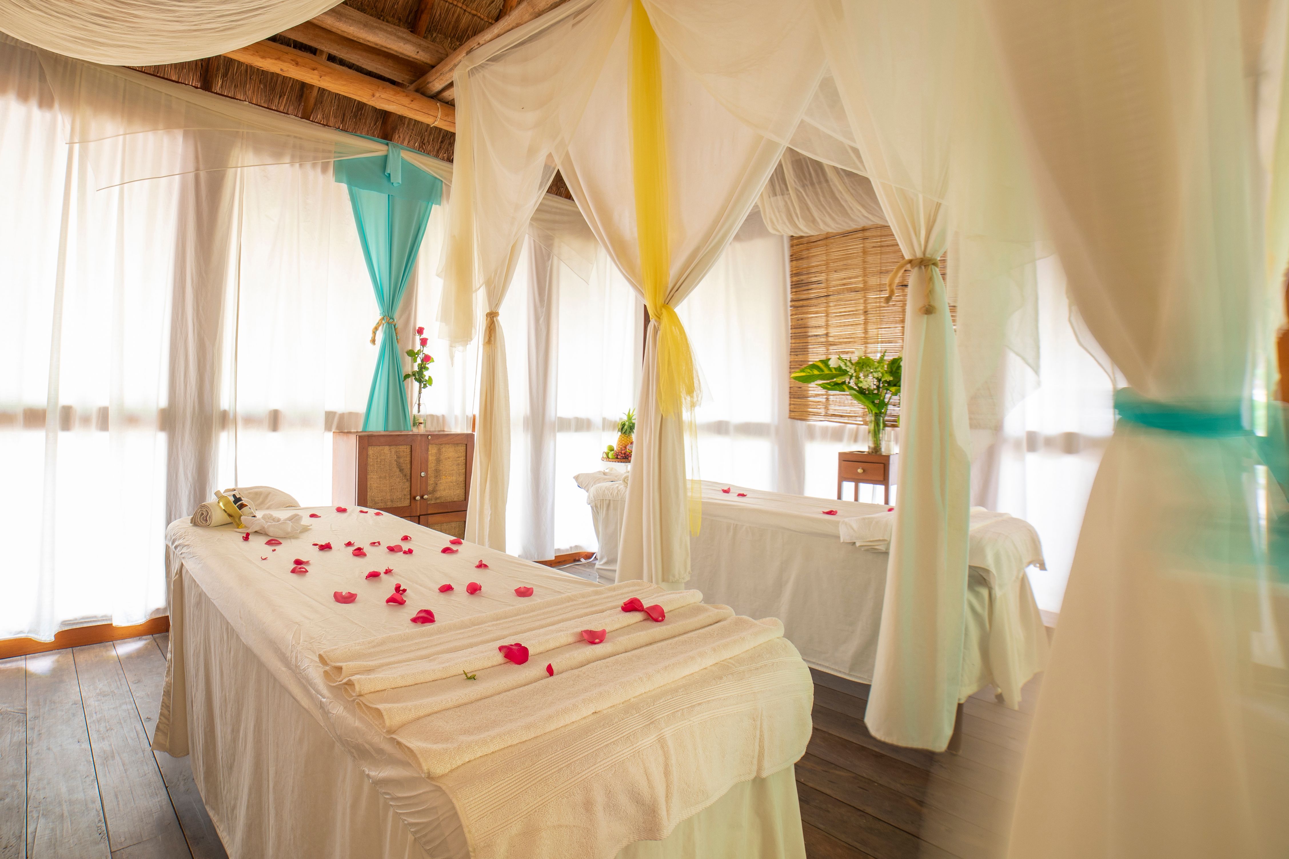 a room with white beds and flowers