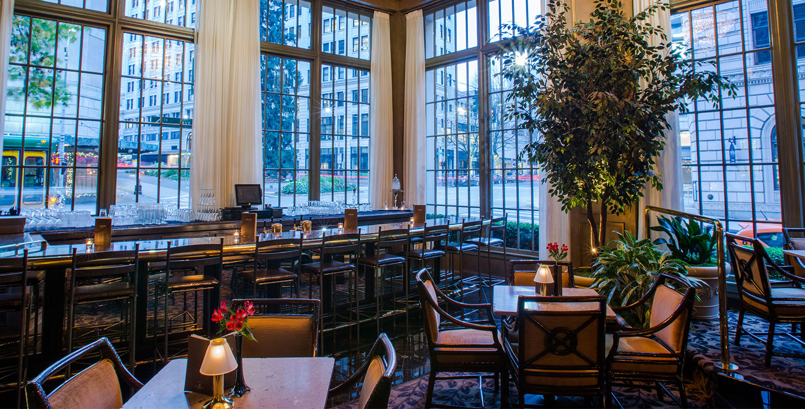 a room with tables and chairs and a tree