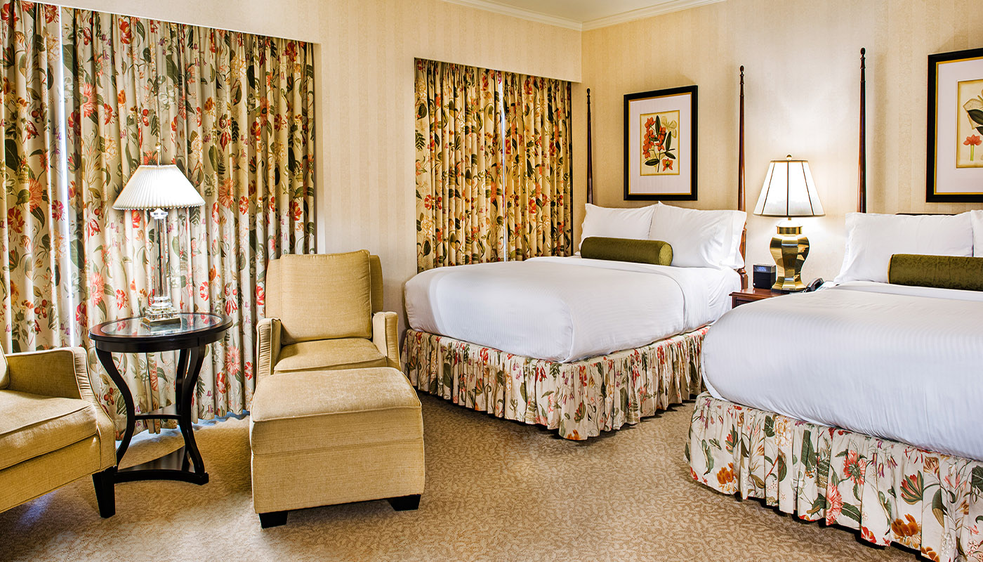 a hotel room with two beds and a chair