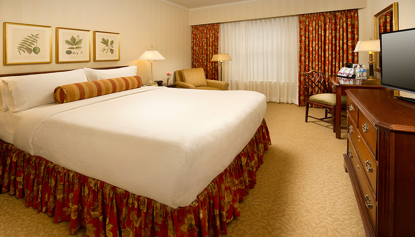 a hotel room with a bed and chairs