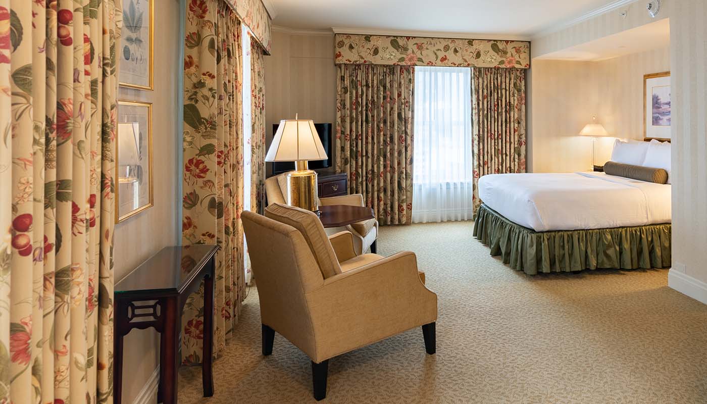 a room with a bed and chairs