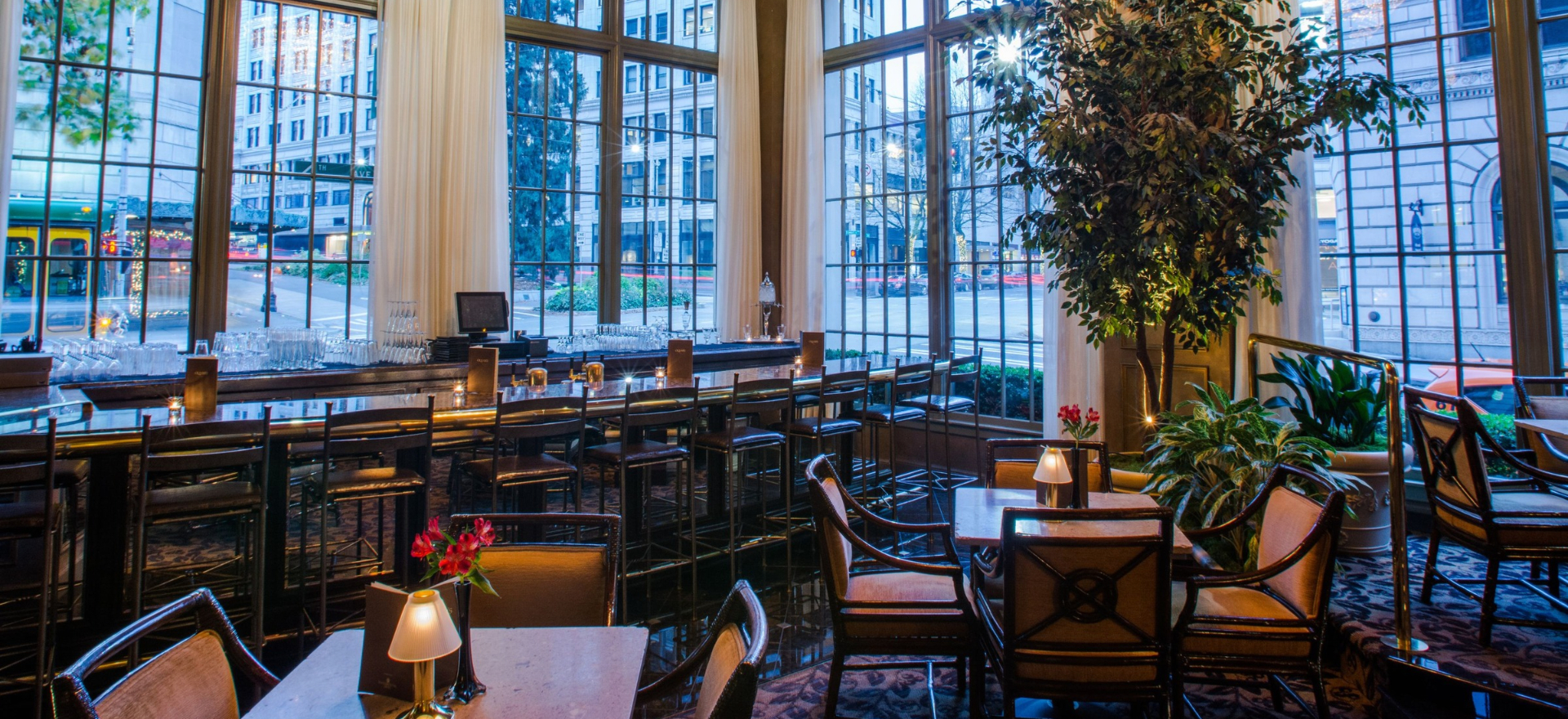 a room with tables and chairs and a large window