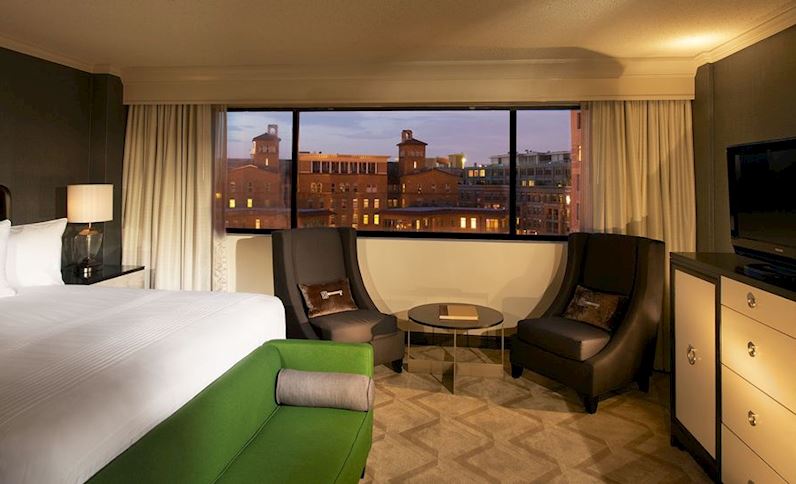 a room with a bed and chairs